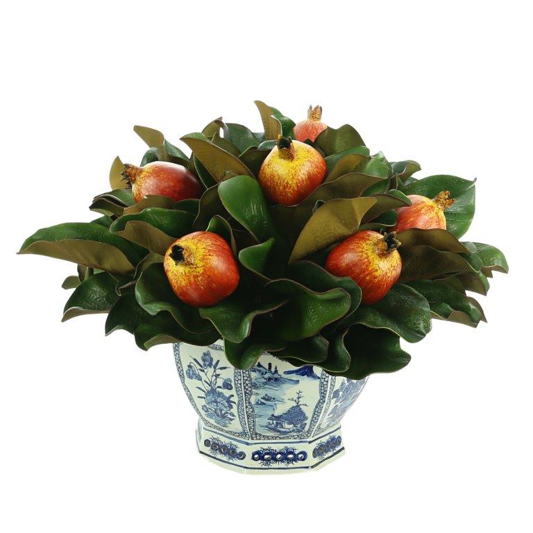 Pretty pomegranate and magnolia midsized arrangement in blue/white pierced planter